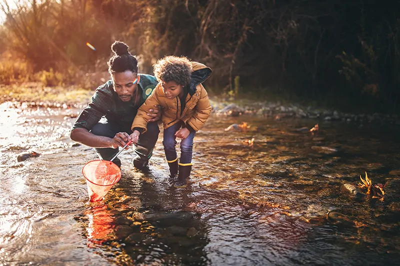 Image of international doctor and his son in a pond fishing
